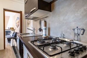 A modern kitchen with a gas stove, stainless steel appliances, and a minimalist design.