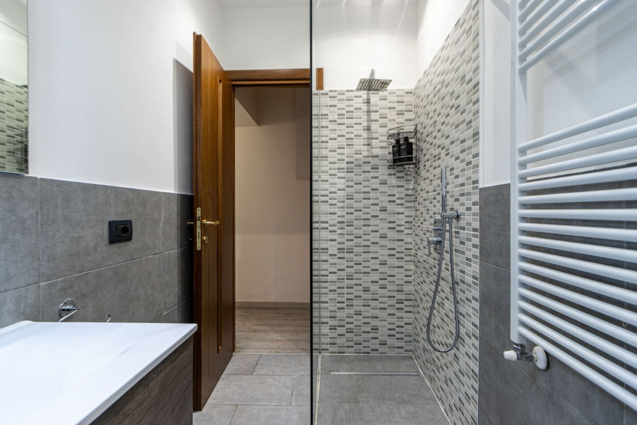 Een douche, een bidet, handdoeken, toiletpapier