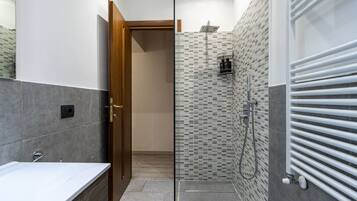 Een douche, een bidet, handdoeken, toiletpapier