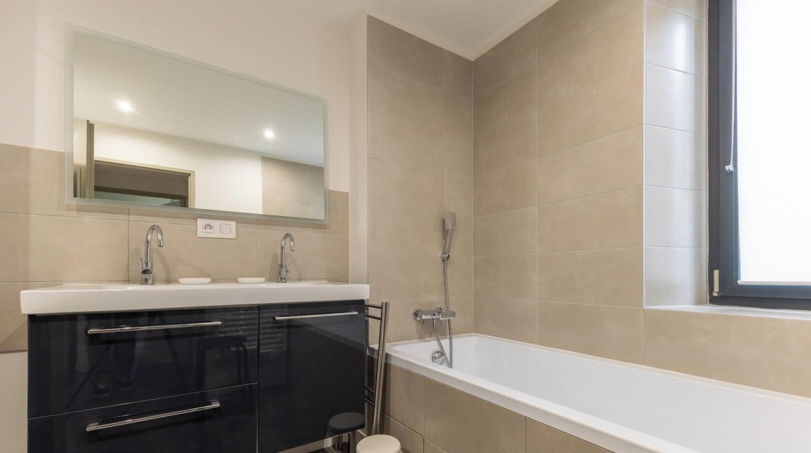 Une salle de bain moderne avec un lavabo, un miroir et une douche.