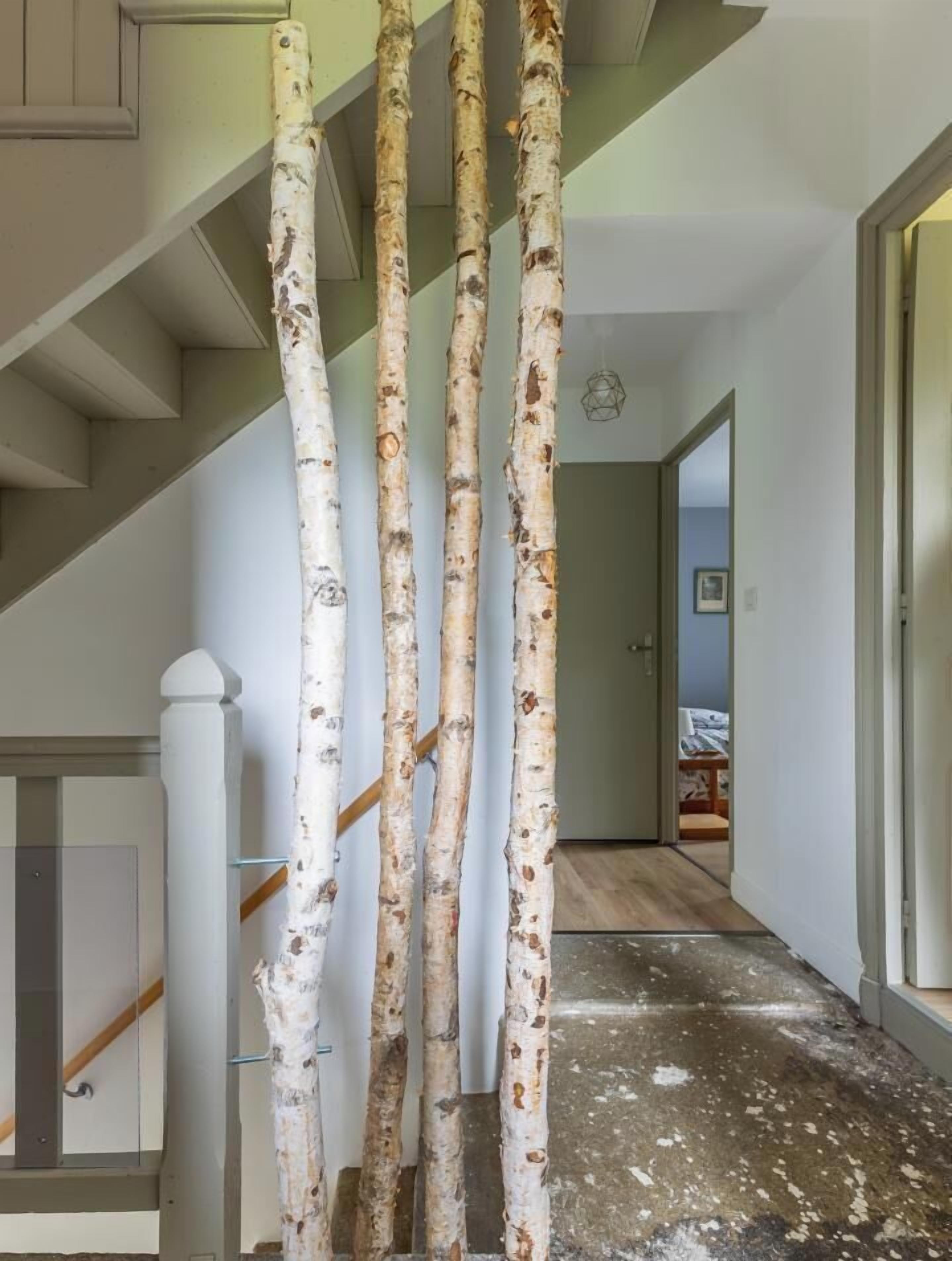 Un escalier avec une balustrade blanche, un plancher en bois et une porte donnant sur une autre pièce.