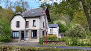 A two-story house with a stone facade, a sloped roof, and a small balcony. - House La Couze - CHAMBON SUR LAC (CHAMBON SUR LAC)