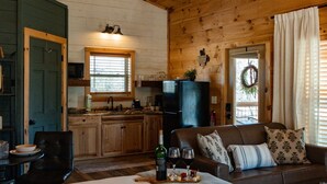 A cozy cabin interior with a dining area, kitchen, and living room. - Smoky Mountain Cabin: Hot Tub, BBQ & Fire Pit (Sevierville)