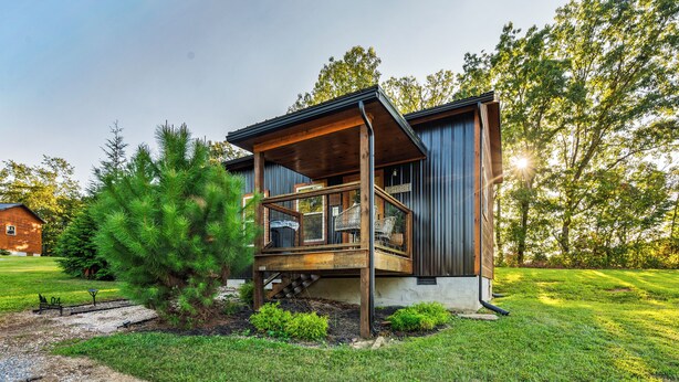 A modern house with a wooden deck, a small staircase, and a well-maintained lawn. - Smoky Mountain Cabin: Hot Tub, BBQ & Fire Pit (Sevierville)