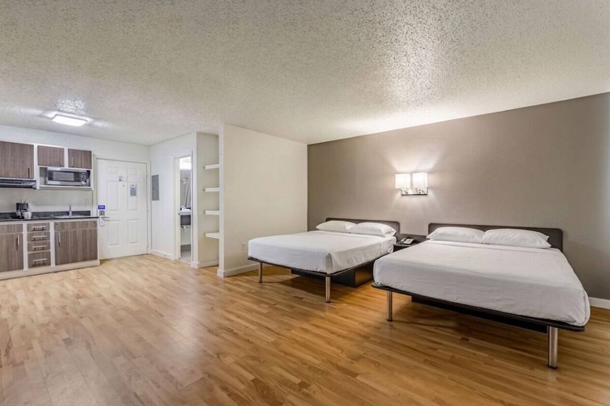 Ein modernes Apartment mit zwei Einzelbetten, einer Küchenzeile und einem Badezimmer.