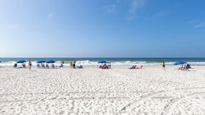 A sandy beach with umbrellas and beach chairs. - Gulf Front 3rd Floor 2/2 - Large Balcony - Keyless Entry - Steps From the Beach (Gulf Shores)