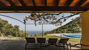 A covered outdoor seating area with a pool and a view of the sea. - House "Tramuntana" - Valldemossa (Son Maxella)