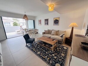 Ein modernes Wohnzimmer mit einer Couch, einem Couchtisch und einem gemusterten Teppich.