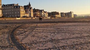 En strand med byggnader i bakgrunden.
