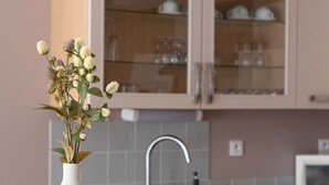 Una cocina con un florero de flores en la encimera, un lavaplatos, armarios y un microondas.