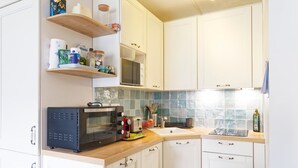 Eine Küche mit weißen Schränken, einer Mikrowelle, einem Toaster und einer Holzarbeitsplatte.