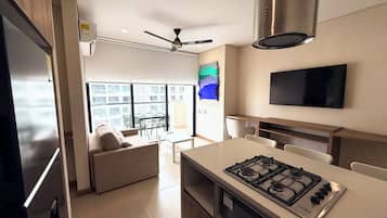 Een moderne keuken met een gasfornuis, een plafondventilator en een flatscreen televisie aan de muur.