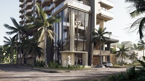 Un immeuble moderne à plusieurs étages, doté de balcons, de grandes fenêtres et de palmiers.