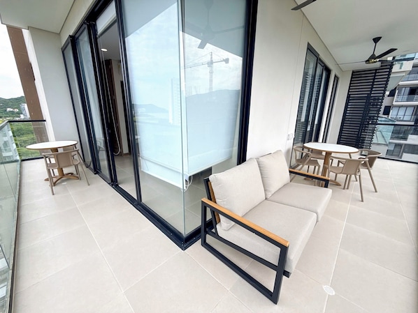 Un balcon moderne avec un canapé, des chaises et une table.