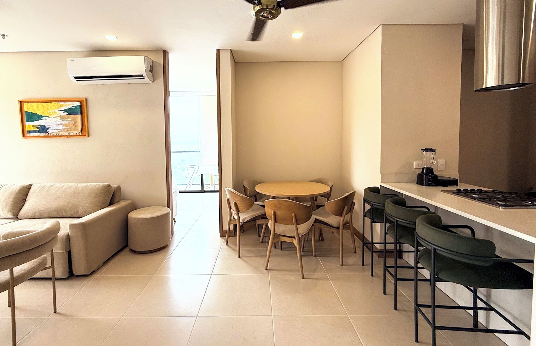 Cozinha moderna com área de refeições, incluindo sofá, cadeiras e mesa.