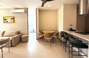 Una cocina moderna con comedor, que incluye un sofá, sillas y una mesa.