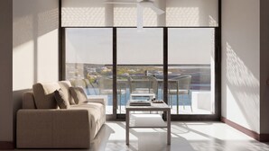 A modern living room with a sofa, a coffee table, and a view of a balcony with chairs. - Nuruma Suites by Avia Suites (Santa Marta)