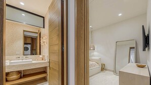 Un baño moderno con tocador de madera, un espejo grande y una lavadora integrada.
