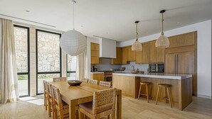 Una cocina moderna con armarios de madera, una isla central e iluminación colgante.