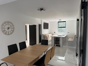 Una cocina moderna con comedor, un reloj y una ventana.