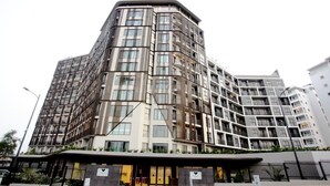 Een hotel met meerdere verdiepingen, met een modern ontwerp, balkons, grote ramen en een plat dak.