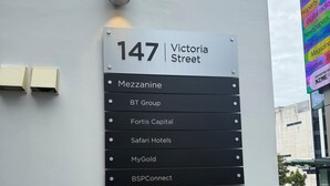 Un cartel con la dirección '147 Victoria Street' que enumera varios negocios como Mezzanine, BT Group y Safari Hotels.