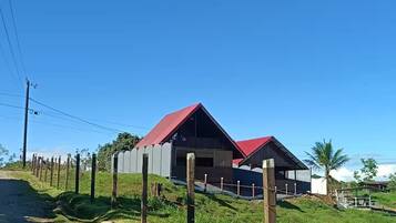 Een modern gebouw met een rood dak en een omheind gebied.