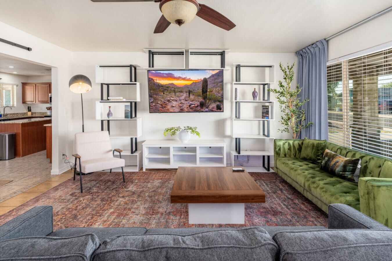 Una sala de estar con un sofá, una mesa de centro, un televisor y una estantería.