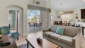 A spacious living room with a sofa, coffee table, and dining area.