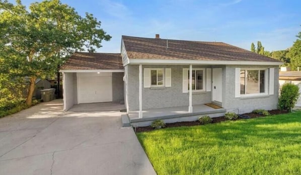 A single-story house with a garage, a front porch, and a well-maintained lawn.