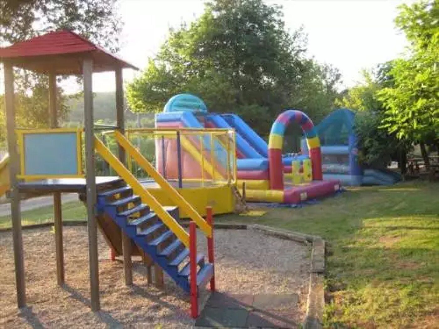 A playground with a slide, a climbing structure, and a small pavilion.