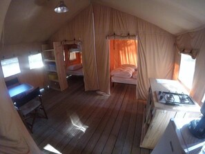 Eine Hütte mit Schlafkoje, Schreibtisch und Herd.