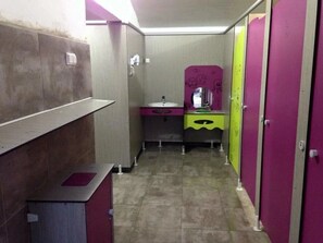 Ein schmaler Gang mit einer Toilette, einem Waschbecken und einem Spiegel mit Graffiti.