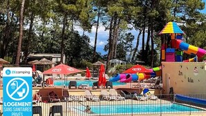 A pool area with a water slide, lounge chairs, and a sign indicating no private toilets.