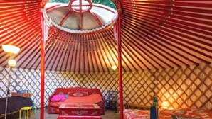 A traditional yurt with a central bed, a small table, and a stool. - ZEcamping 1 étoile 5km plage mobil-home BBQ 20m2 2 pers (Plessix-Balisson)