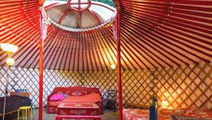A traditional yurt with a central bed, a small table, and a stool. - ZEcamping 1 étoile pet friendly mobil-home BBQ 28m2 5 pers (Plessix-Balisson)