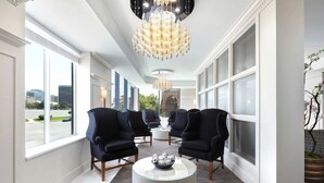 A spacious lobby with a chandelier, seating area, and large windows offering a city view. - Upscale Condo at the Center of It All (Salt Lake City)