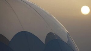 La parte inferiore di un'ala di aereo con il sole sullo sfondo.