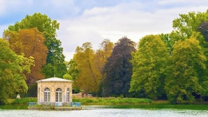 Ein Pavillon am See mit freiem Blick auf die umliegenden Bäume.