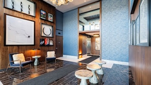 Una hall moderna con reception, area relax e opere d'arte alle pareti.
