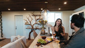 Un ambiente interior acogedor con una mesa de comedor, una rama decorativa y una lámpara colgante.