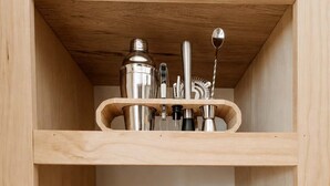 A wooden shelf unit with kitchen utensils and a wine bottle. - Solara Ridge • Serene Escape, Panoramic Views, Spa, and Cowboy Tub (Yucca Valley)