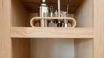 Een houten plankenwand met keukengerei en een wijnfles.