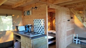 Un interno compatto in legno con angolo cottura, un letto e un piccolo spazio salotto.