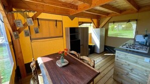 Cucina compatta con mobili in legno, un tavolo da pranzo con sedie e una piccola finestra.