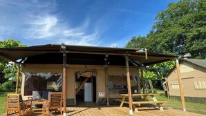 A wooden deck with a covered seating area, a table, and a tent-like structure. - ZEcamping 3* piscine chiens acceptés locatif BBQ 72m2 5 pers (Dévillac)