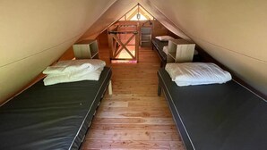 A small attic bedroom with two beds, wooden flooring, and a slanted ceiling. - ZEcamping 3* piscine chiens acceptés locatif BBQ 72m2 5 pers (Dévillac)