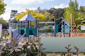 A playground with climbing structures, slides, and a covered play area. - ZEcamping 4* 1km plage piscine chauffée fitness locatif 8m2 2 pers (Saint-Jean-de-Monts)