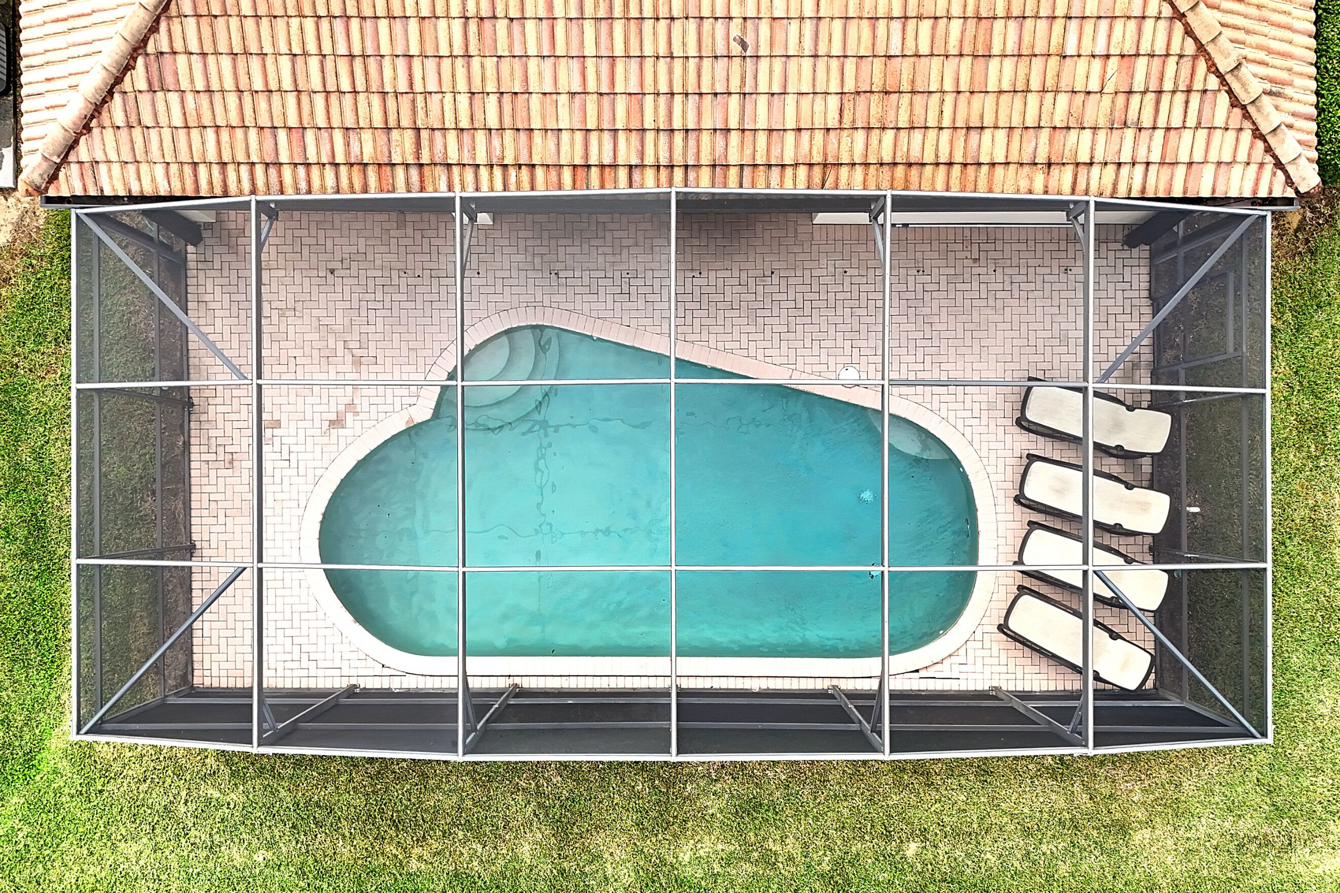 A swimming pool with a brick wall and a metal fence.