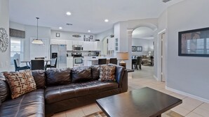 A modern apartment with a living room, dining area, and kitchen.